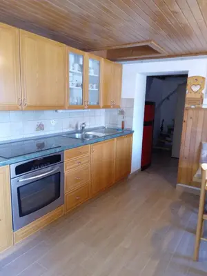 a kitchen with wooden cabinets and a stove top oven at Mountain house MINKA in Srednja Vas v Bohinju