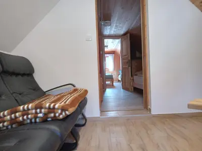a living room with a couch and a hallway at Mountain house MINKA in Srednja Vas v Bohinju