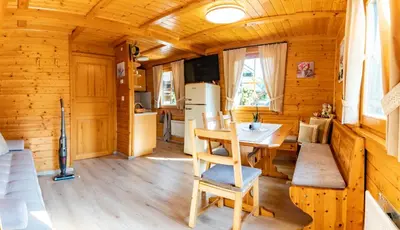a dining room and kitchen in a log cabin at Bella Mura Nature Chalet I27 in Podčetrtek