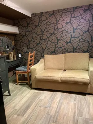 a couch sitting in a living room with a wall at The Lodge in Rogaška Slatina