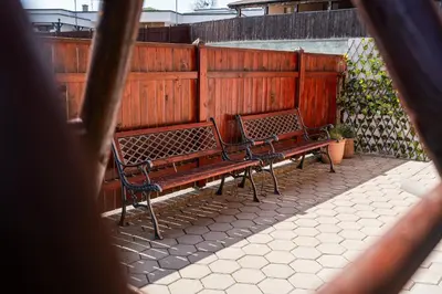 two benches sitting in front of a wooden fence at Perfect stay in Šentilj