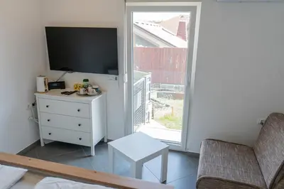 a living room with a tv and a couch and a window at Perfect stay in Šentilj