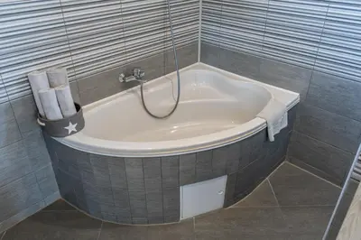 a bath tub with a shower in a bathroom at Perfect stay in Šentilj