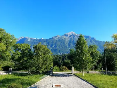 a dirt road with a mountain in the background at Počitniška hiša Nad Sočo in Bovec