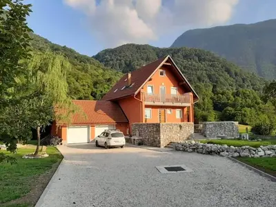 a house with a car parked in front of it at Počitniška hiša Nad Sočo in Bovec