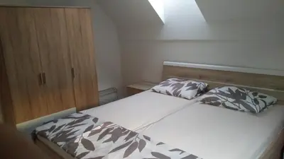a bedroom with a bed and a wooden cabinet at Počitniška hiša Nad Sočo in Bovec