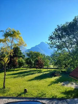 a view of a field with mountains in the background at Počitniška hiša Nad Sočo in Bovec