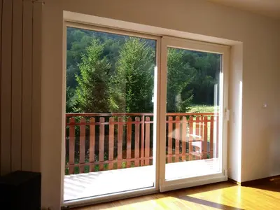 a sliding glass door with a view of a balcony at Počitniška hiša Nad Sočo in Bovec