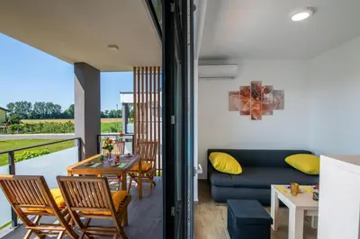a living room with a couch and a table and chairs at Apartmaji BANONIA in Veržej