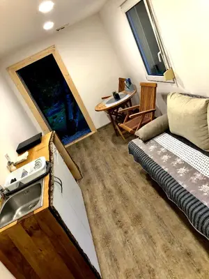 a tiny house with a sink and a bed and a window at Skalca in Kamniška Bistrica
