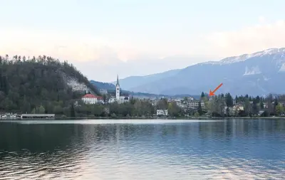 a large lake with a town and a church at Lakefront Bled - Rooms & Apartments in Bled
