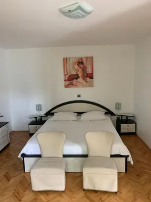 a bedroom with a large bed with two chairs at Apartmaji Klabjan - Kaki in Osp