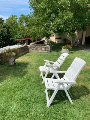 three white lawn chairs sitting in the grass at Apartmaji Klabjan - Kaki in Osp