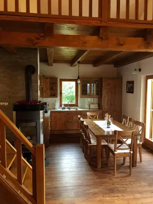 a large kitchen with a table and a stove at Gozdarjeva koča nad Rimskimi Toplicami in Dol pri Hrastniku