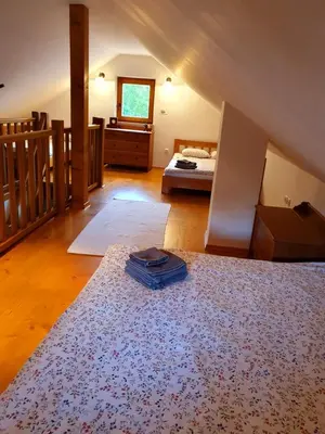 a bedroom with a bed and a rug on the floor at Gozdarjeva koča nad Rimskimi Toplicami in Dol pri Hrastniku
