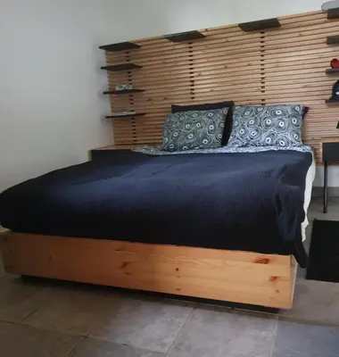 a bedroom with a bed with a wooden headboard at Gozdarjeva koča nad Rimskimi Toplicami in Dol pri Hrastniku