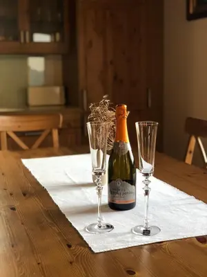a bottle of champagne and two wine glasses on a table at Gozdarjeva koča nad Rimskimi Toplicami in Dol pri Hrastniku