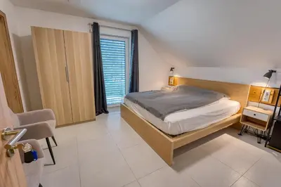 a bedroom with a bed and a desk and a window at Rooms Minka in Kamna Gorica