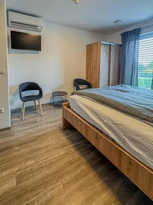 a bedroom with a bed and two chairs at Rooms Minka in Kamna Gorica