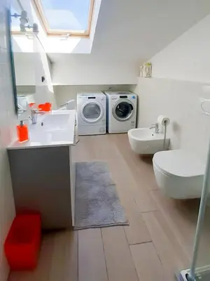 a bathroom with a washing machine and a washer and dryer at Istriana boutique apartment in Nova Gorica