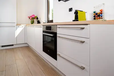 a kitchen with white cabinets and a black oven at Istriana boutique apartment in Nova Gorica