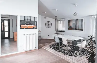 a dining room with a white table and a car on the wall at Istriana boutique apartment in Nova Gorica