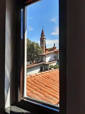 a view from a window of a roof with a clock tower at Istriana boutique apartment in Nova Gorica