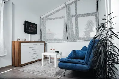 a living room with a blue chair and a table at Istriana boutique apartment in Nova Gorica