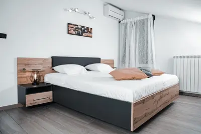 a bedroom with a large bed with a wooden headboard at Istriana boutique apartment in Nova Gorica