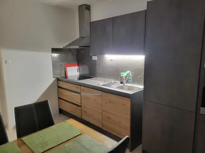 a small kitchen with a sink and a table at Apartma Patrik in Kobarid