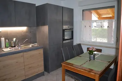 a small kitchen with a table and a sink at Apartma Patrik in Kobarid