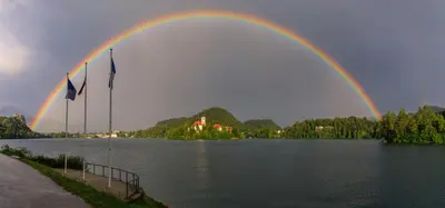 a rainbow over a body of water with trees and houses at Apartment Mavrica Bled in Bled
