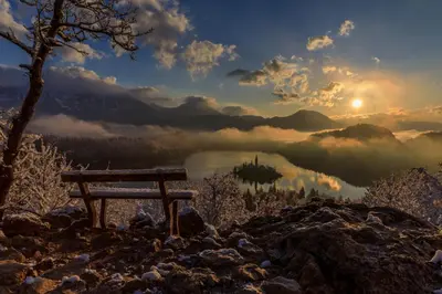 a bench on a mountain with a view of a lake at Apartment Mavrica Bled in Bled