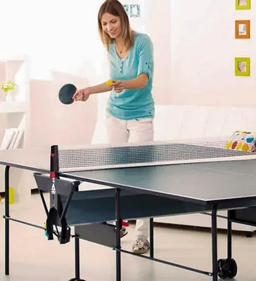 a woman playing tennis on a ping pong table at Apartment Mavrica Bled in Bled