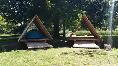 two tents sitting on the grass in a park at Kamp na Otoku - Ljubno ob Savinji in Ljubno