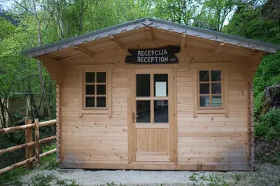 a small wooden shed with a sign on it at Kamp na Otoku - Ljubno ob Savinji in Ljubno