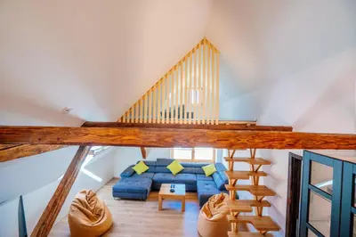 a living room with a blue couch and a staircase at Stol Apartments in Žirovnica