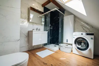 a bathroom with a washing machine and a sink at Stol Apartments in Žirovnica