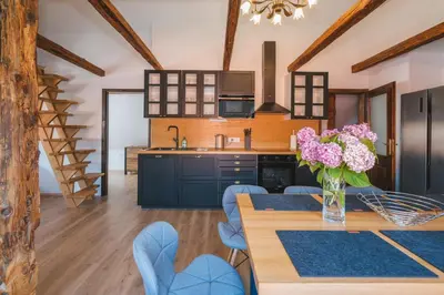 a kitchen with a table with a vase of flowers at Stol Apartments in Žirovnica