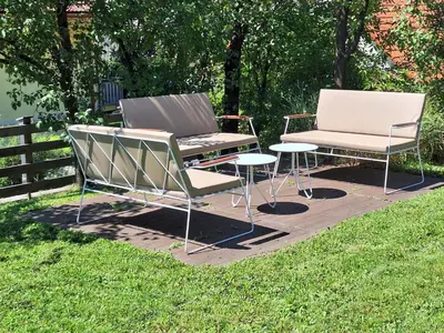 two chairs and a table in the grass at Stol Apartments in Žirovnica