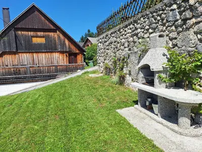 a stone bench next to a stone wall with a building at Stol Apartments in Žirovnica
