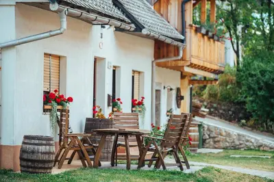a wooden table and chairs in front of a building at Stol Apartments in Žirovnica