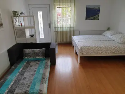 a bedroom with a bed and a couch in it at Studio EMMA Ljubljana - FREE parking, AC, Wifi in Ljubljana