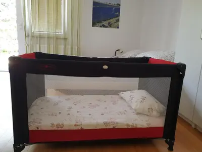 a small black bed with a pillow in a room at Studio EMMA Ljubljana - FREE parking, AC, Wifi in Ljubljana