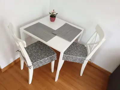 a white table and two chairs with a plant on it at Studio EMMA Ljubljana - FREE parking, AC, Wifi in Ljubljana