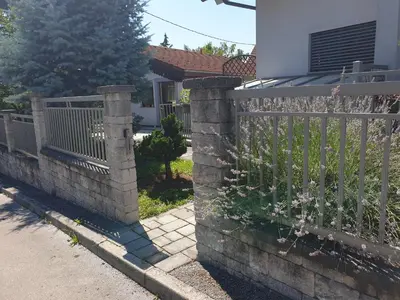 a stone fence in front of a house at Studio EMMA Ljubljana - FREE parking, AC, Wifi in Ljubljana