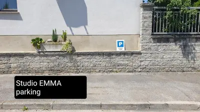 a sign on the side of a building with plants at Studio EMMA Ljubljana - FREE parking, AC, Wifi in Ljubljana