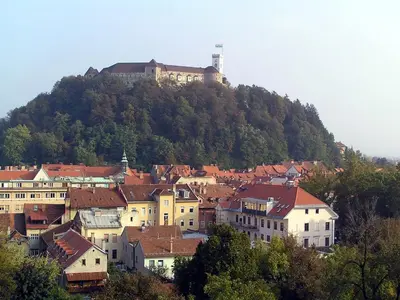 a town on a hill with a castle on top of it at Studio EMMA Ljubljana - FREE parking, AC, Wifi in Ljubljana