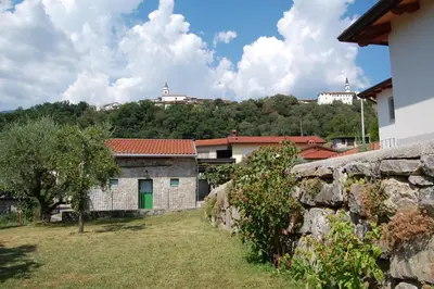 a stone wall and a building in a village at Apartma HIŠKA in Dobravlje