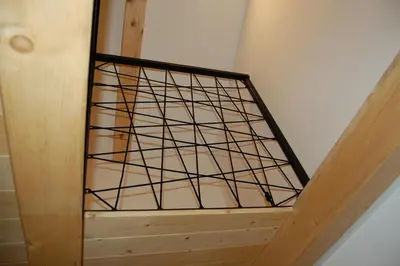 a wooden stair case with a metal grate on it at Apartma HIŠKA in Dobravlje